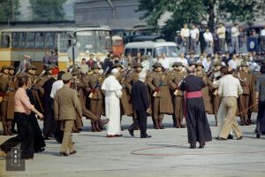 Fragment uroczystości. W środku widoczny papież Jan Paweł II. Widoczni także uczestnicy uroczystości m.in. żołnierze, biskupi i kardynałowie.